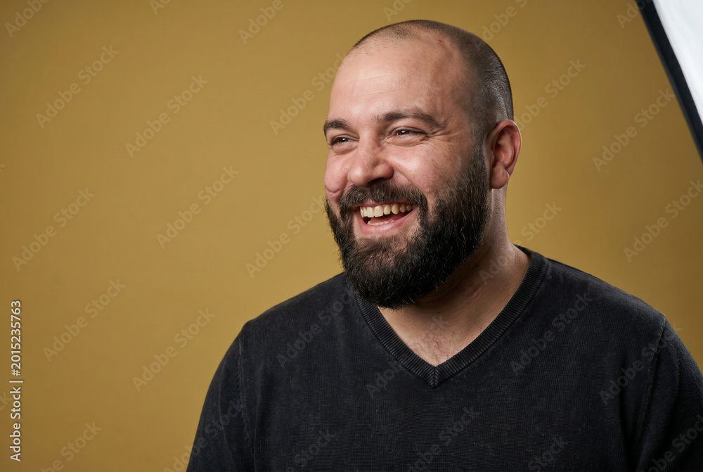 Fototapeta premium Joyful Bearded Man Laughing on Yellow Background