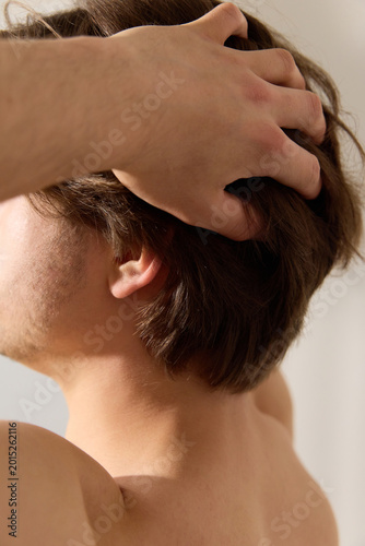 A man touches his long hair. Real life photography
