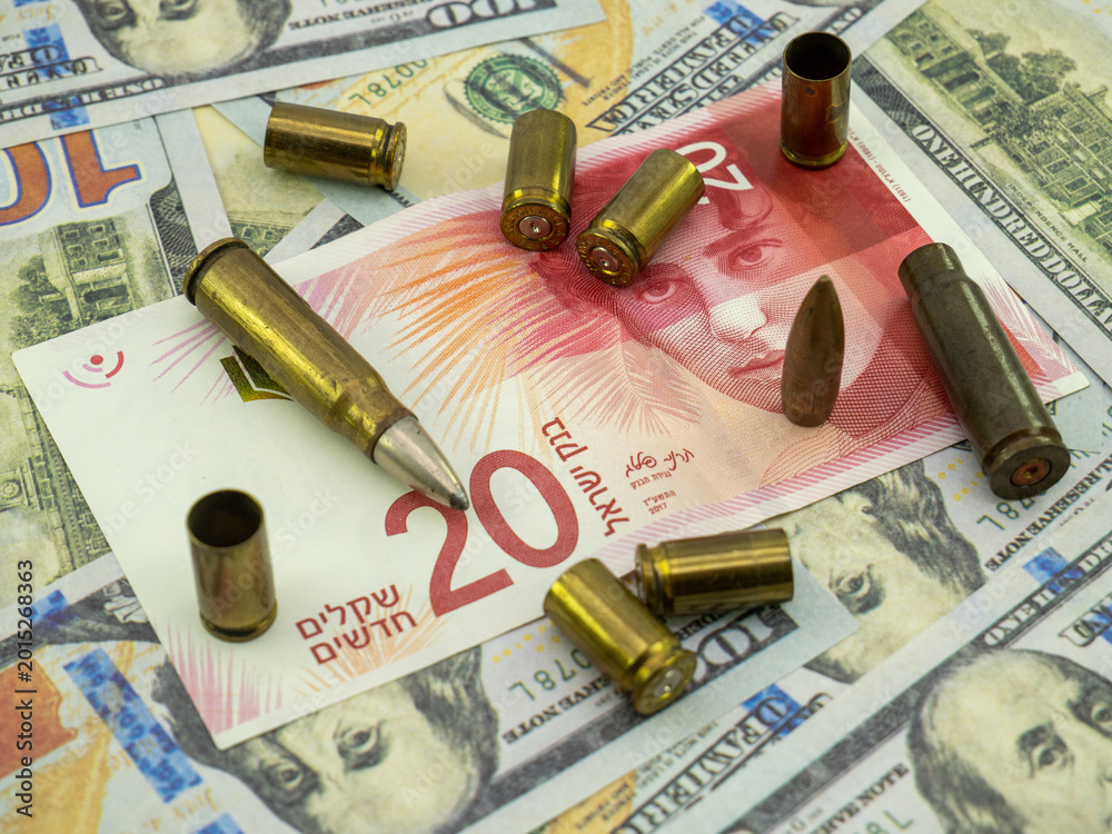 Naklejka premium israeli shekel and american hundred dollar banknotes and cartridges, arming concept
