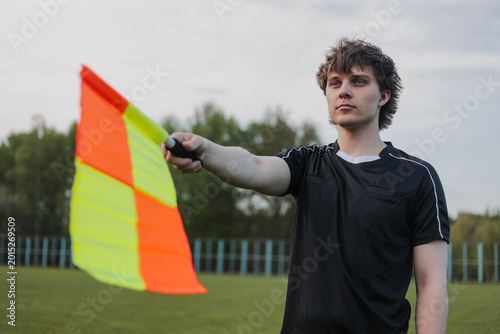 Foto Soccer referee signaling offside with a flag during football match