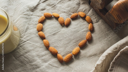 Heart Shaped Raw Almonds with Dairy-Free Plant Milk on Rustic Linen Background