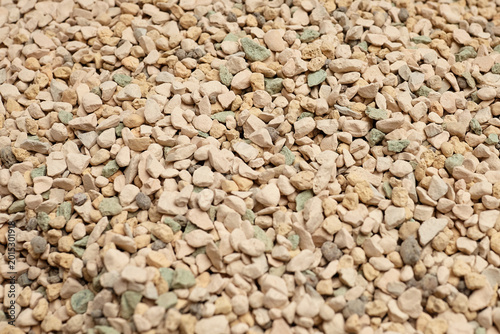 Mineral substrate soil composed of small, irregularly shaped stones in various shades of beige and green, ideal for succulent plants and gardening applications
