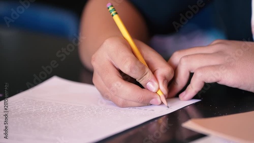 Student Writing Notes on a Piece of Paper
