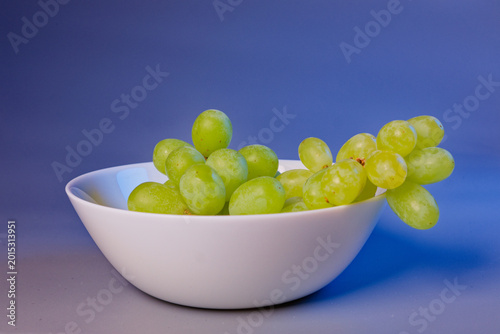 Grape fruit on bowl still life on blue background