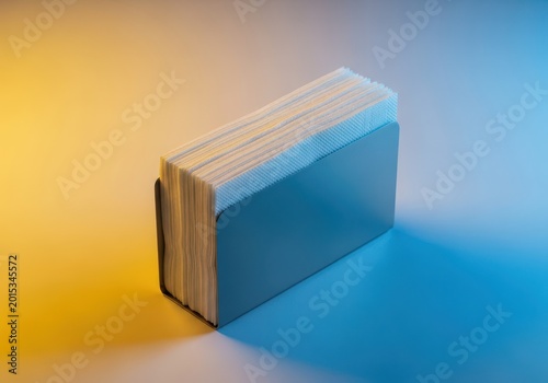 Practical table setting accessory, a metal rectangular container filled with clean white paper napkins ready for diners, cup, setting, surface