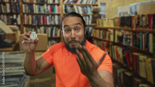 Obraz na plátně Man holds stopwatch and reaches hand forward in library building while smiling and showing stopwatch to camera; urgency time pressure