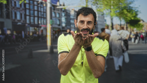 Tableau sur toile Middle age man referee with beard wearing neon shirt and whistle on lanyard gesturing open palms toward pedestrians on street; friendly guidance