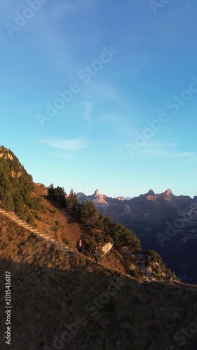 Drone view of two hikers walking on ridge stairs at Stoos Fronalpstock, Switzerland
