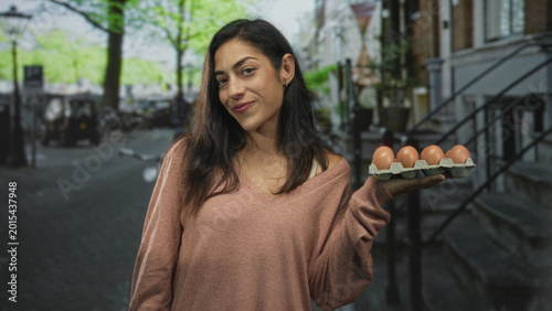 Foto Woman holds tray of eggs with bare hands on street beside parked bicycles and stone stoop steps; urban simplicity contentment