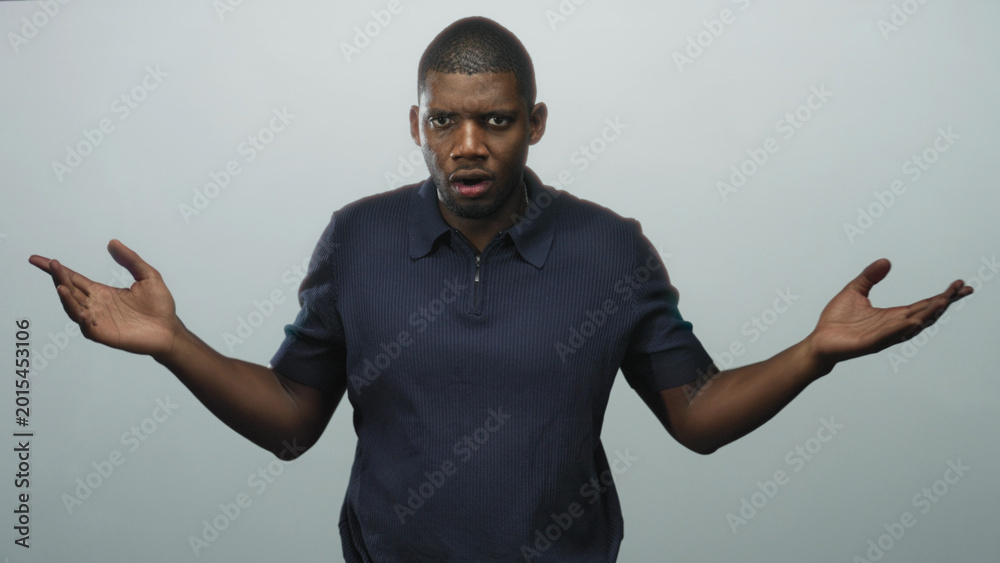 Fototapeta premium Man pinching bridge of nose with hand and folded arm in studio wearing polo shirt, then opens hands in a shrug sequence; frustration tension.