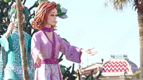 Sunny daytime parade of satirical masked carri allegorici advancing on Viareggio passeggiata mare Italy festival