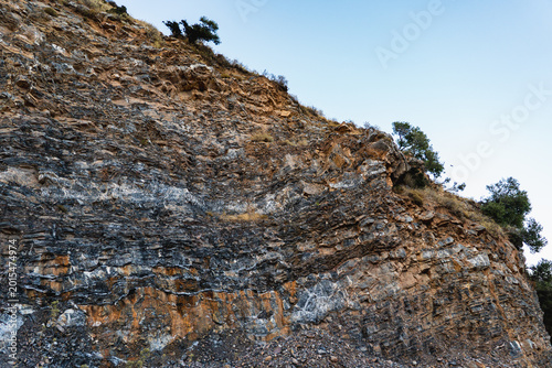 Bild auf Leinwand landscape of a mountain slope with sparse vegetation and layers of limestone roc