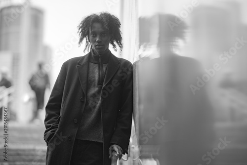 Confident Young Man with Reflection in City Window Monochrome Style with Copy Space