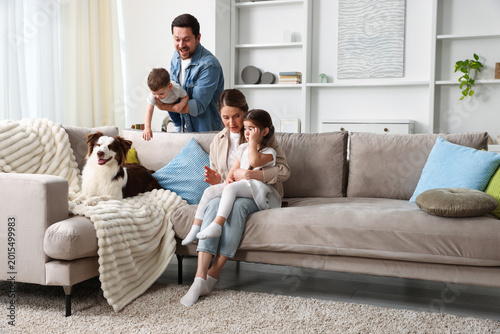 Happy family and their dog on sofa at home