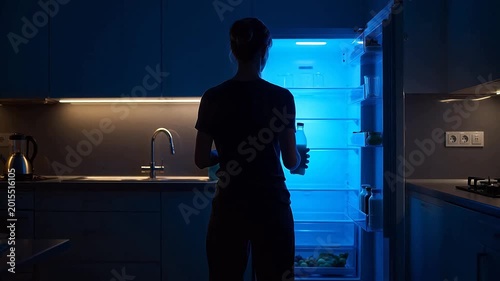 Person opening fridge in kitchen at night ideal for restaurant branding and gastronomy vlogs