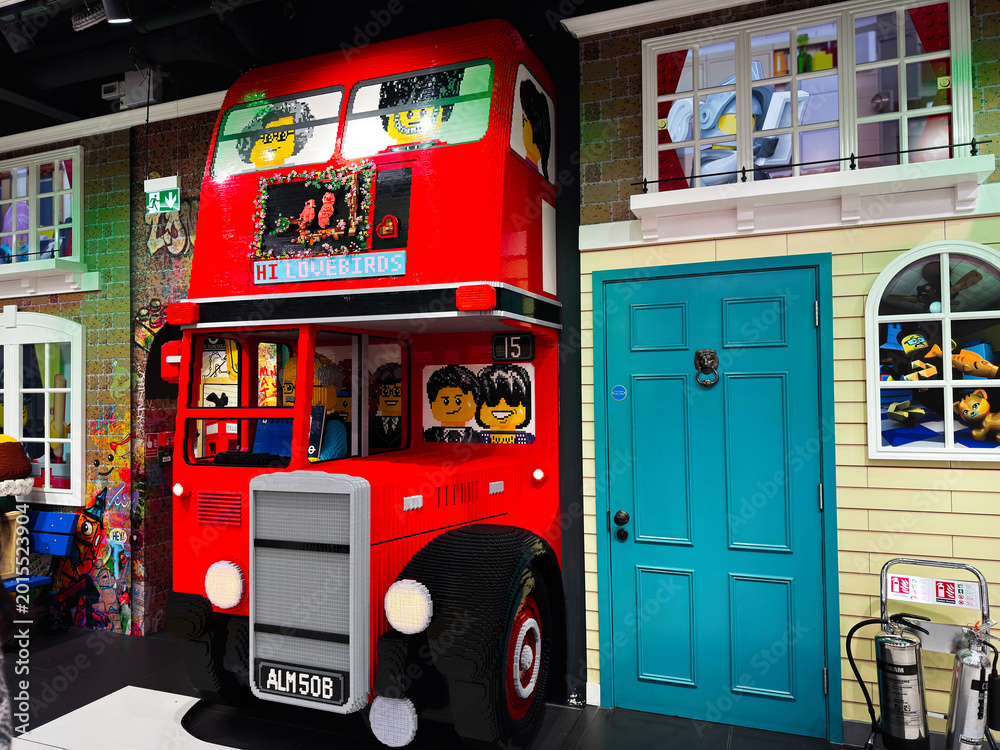 Obraz premium Bright Lego double decker bus installation inside a toy store facade in London UK with playful characters, colorful bricks, family friendly display and interactive children's attraction