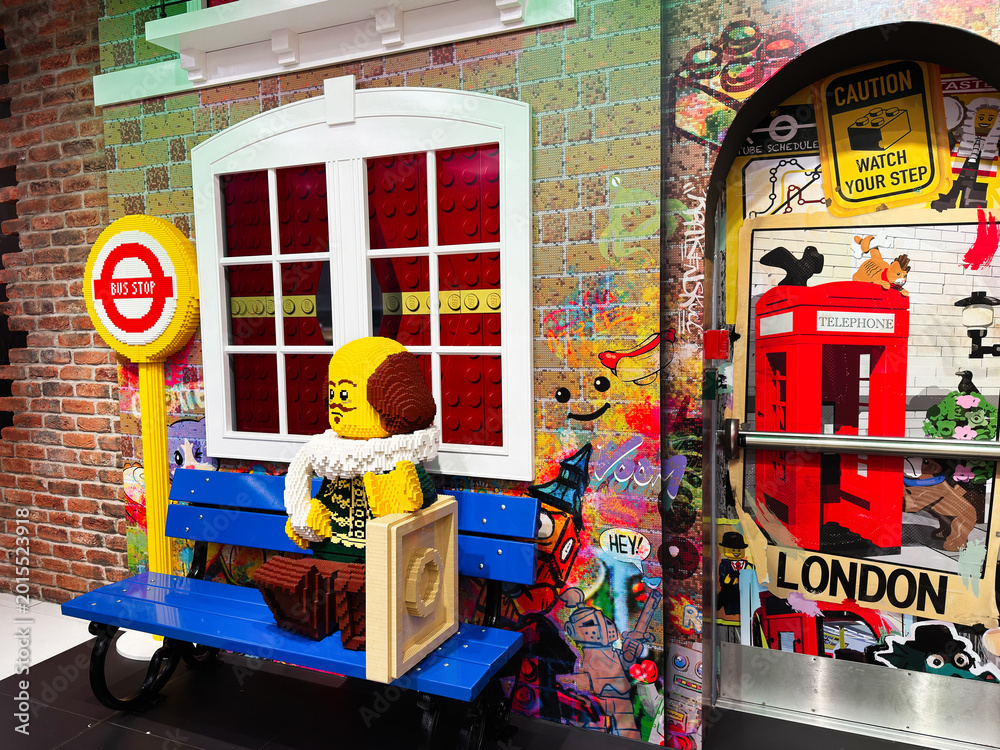 Obraz premium Colorful Lego bench scene at a London, UK bus stop with red telephone box, graffiti wall and playful brick sculpture
