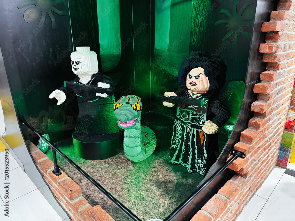 Obraz premium Lego villain figures display featuring Voldemort Bellatrix and Nagini in a green forest window set at a London UK toy store