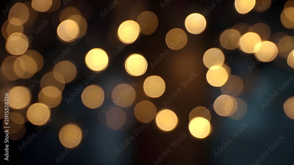 Obraz premium A soft and warm abstract background featuring glowing defocused golden bokeh lights