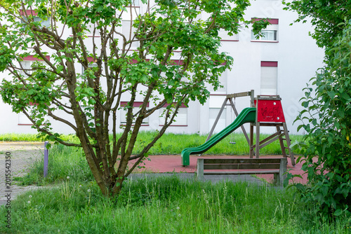 Billede på lærred Aire de jeux pour enfants dans une résidence urbaine avec toboggan et verdure