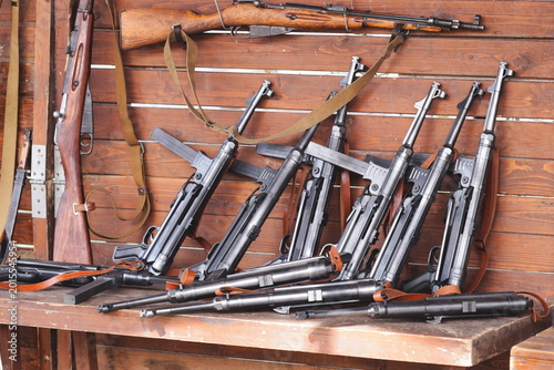 Photos Various assault rifles placed neatly on a table, suitable for use in military or