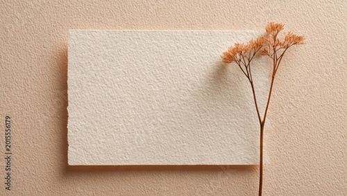 Blank handmade paper card mockup with dried flower on peach background