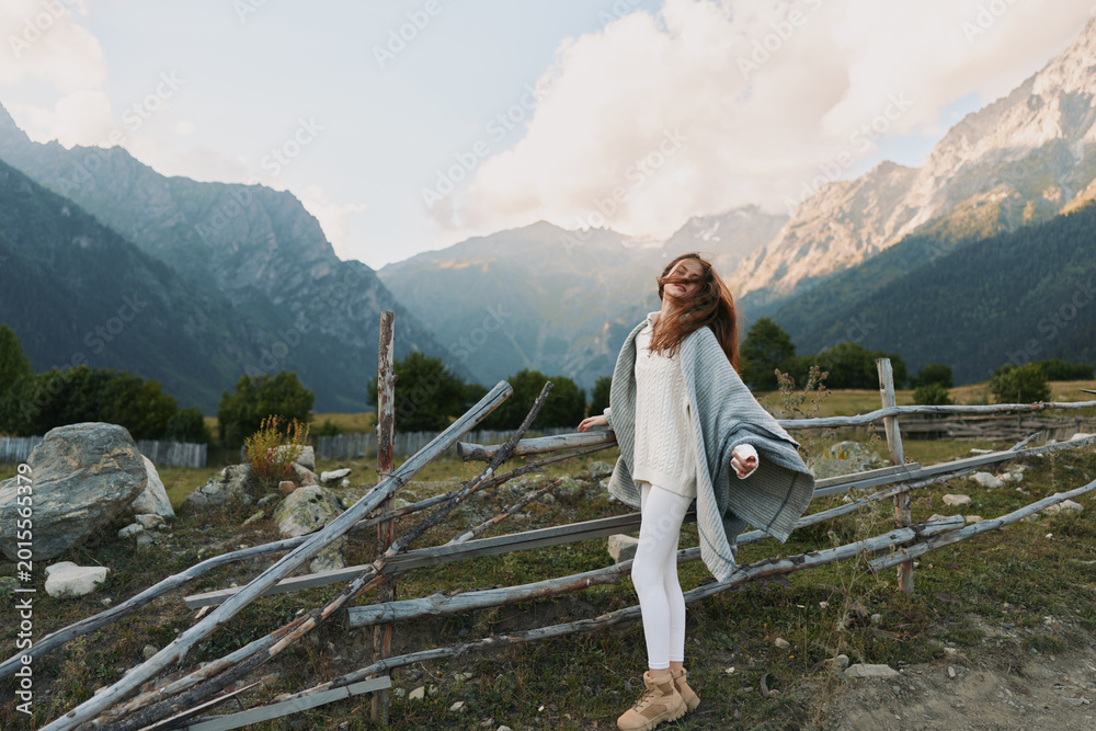 Obraz premium Cheerful woman outdoors, enjoying mountains, scenery, casual outfit, flowing cardigan, sunlit air, relaxed pose, natural colors, alpine landscape, carefree mood