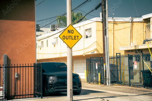 Tableau sur toile Yellow no outlet street sign warns drivers on a sunny day