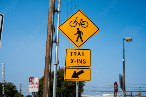 Schilderij op canvas Yellow diamond sign warns of trail crossing for pedestrians and cyclists
