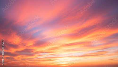 Vibrant orange sunset with purple clouds in the sky at dusk