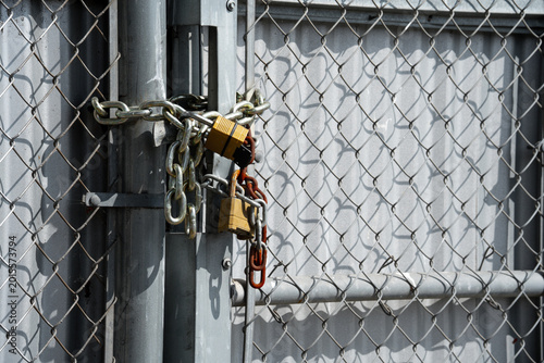 Tableau sur toile Heavy duty chain and padlocks securing a metal gate against unauthorized access