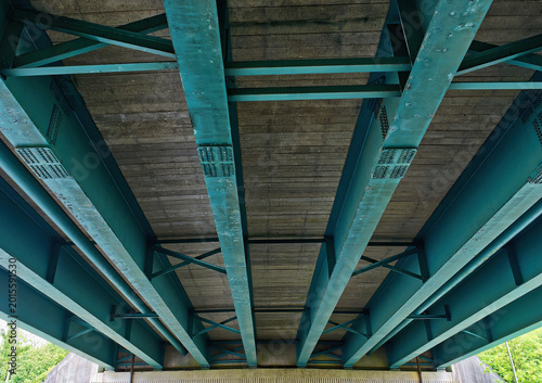 Photos The underside of a plate girder bridge with turquoise I-beams, England, UK