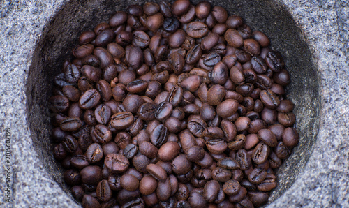 Foto Roasted coffee beans in a mortar or grinding stone will be grounding manually