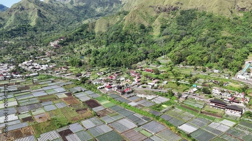 Aerial View of Lush Green Mountains, Cultivated Farmlands, and a Serene Rural Village