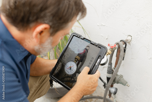 A home inspector checking water pressure with a water pressure meter