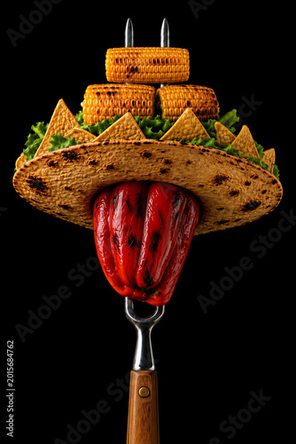grilled red pepper wearing a crispy tortilla sombrero with nachos, lettuce, and grilled corn, skewered on a metal barbecue fork with a wooden handle.
