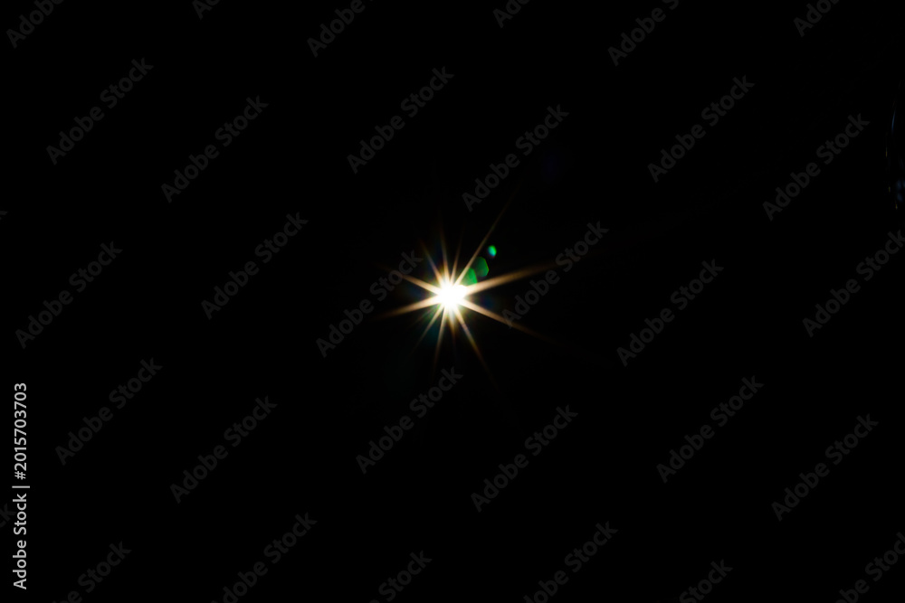 Fototapeta premium Symmetrical ten-point star flare with green chromatic aberration dots on a black background. Sharp geometric light burst for scientific or futuristic visuals.