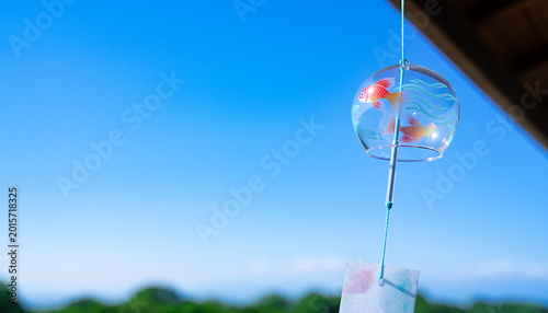 Fotografie 金魚柄ガラス風鈴と屋根の青空背景（夏の和風風物詩素材）