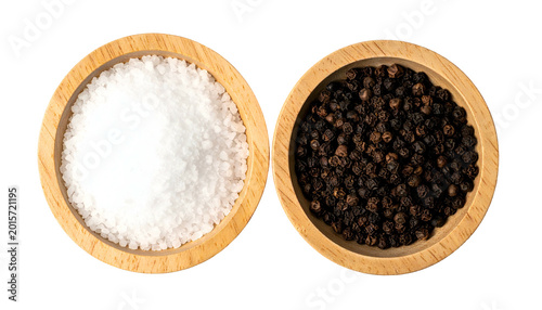 Salt and pepper in wooden bowls, viewed from above, on dark background