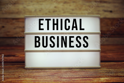 Foto Lightbox with text Ethical Business on wooden background