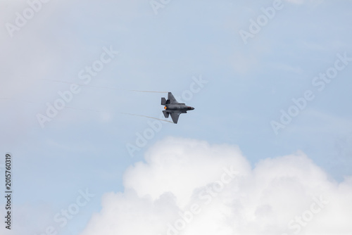 American 5th generation stealth fighter jet of the US Air Force performing aerial maneuvers in cloudy skies. Powerful modern military aircraft flying during aviation demonstration