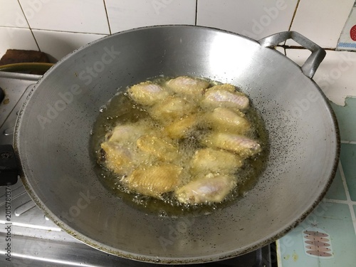Pan fried potatoes with onions in a frying pan on a stove in a kitchen meal preparation