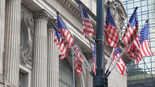 American flags near Grand Central Terminal on 42 street, New York City, Manhattan Midtown. Railway building architecture in United States. Public railroad transport junction. Old station exterior.