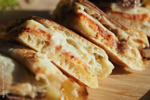 Obraz na płótnie Melted cheese sandwich served on a wooden board