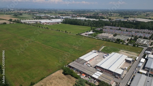 Foto Aerial View of Industrial Area: An expansive shot showcasing the harmonious blend of green fields and industrial infrastructures, illustrating the dynamics of modern urban development