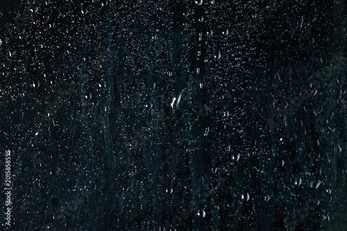 Transparent water droplets glass window overlay black background photo.