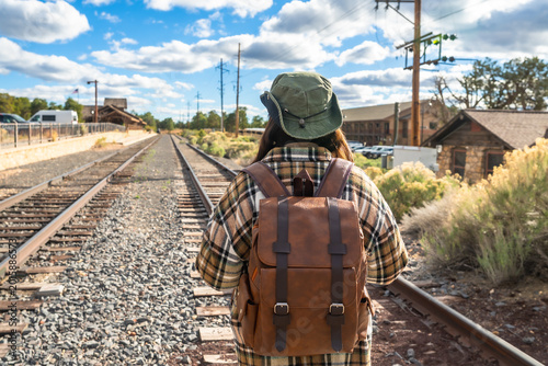 Fotografía Traveler walking along railway tracks heading to adventure