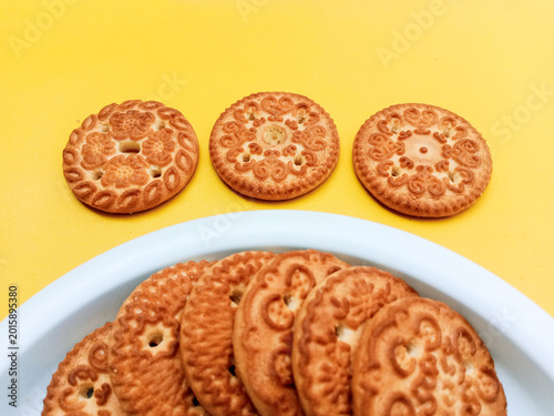 Round Wheat Biscuits with Floral Pattern on Yellow Background