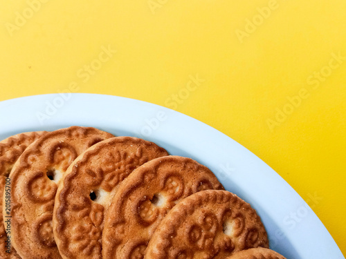 Close Up of Wheat Biscuits on a White Plate with Yellow Background