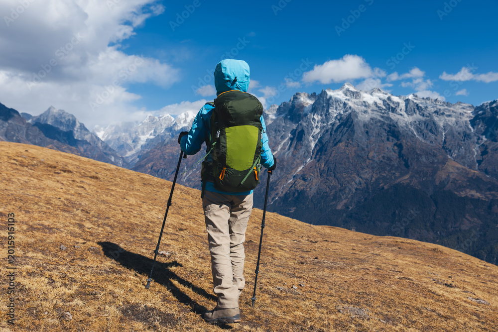 Obraz premium Backpacking woman hiking on high altitude mountain top